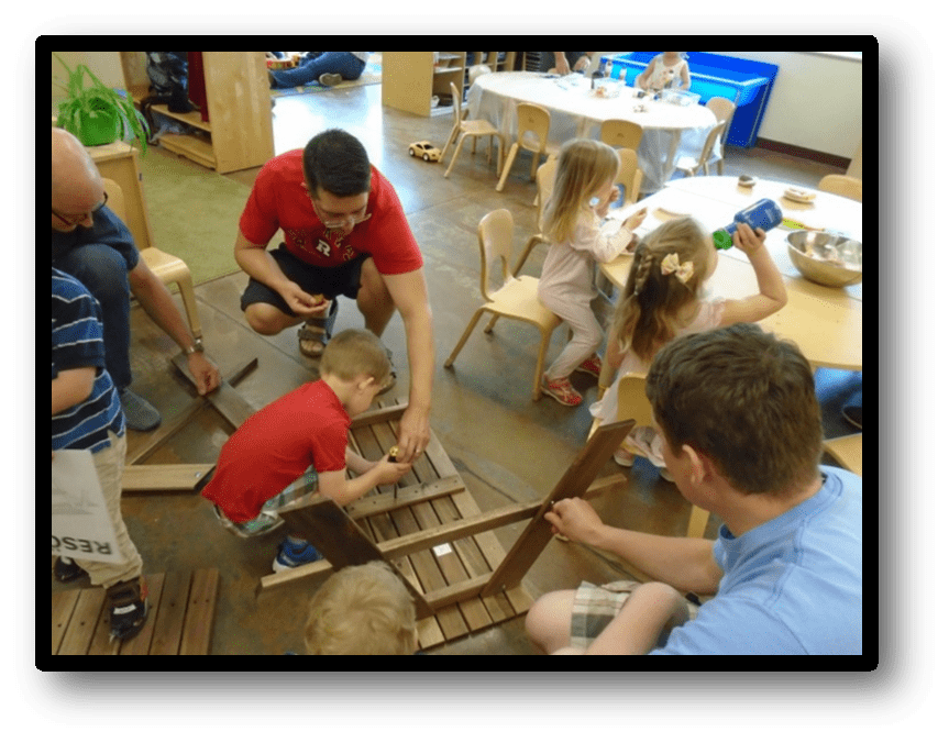 Fathers and kids working on building picnic tables together