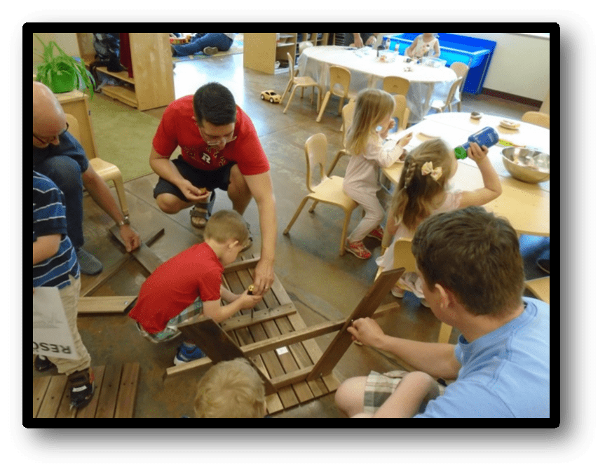 Fathers and kids working on building picnic tables together